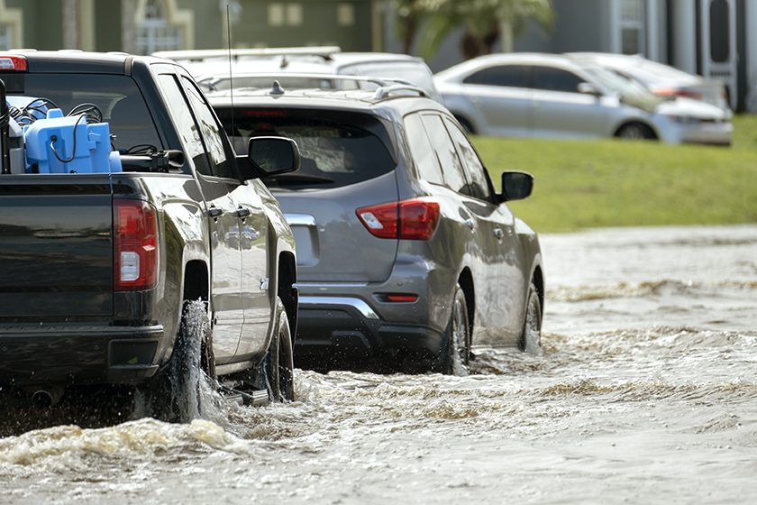 Cars driving through flooded road during Flash Flood Alert